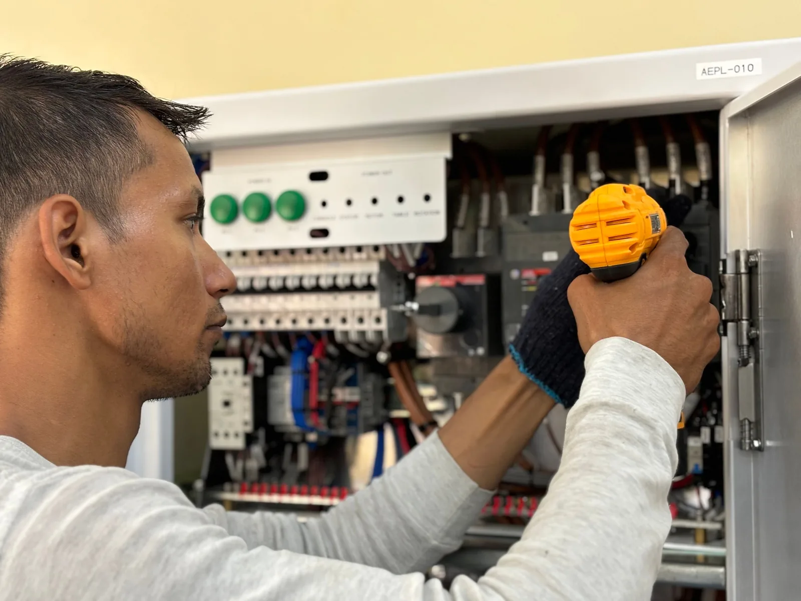 An electrician working on a commercial control panel, for subpanel installation in Calgary