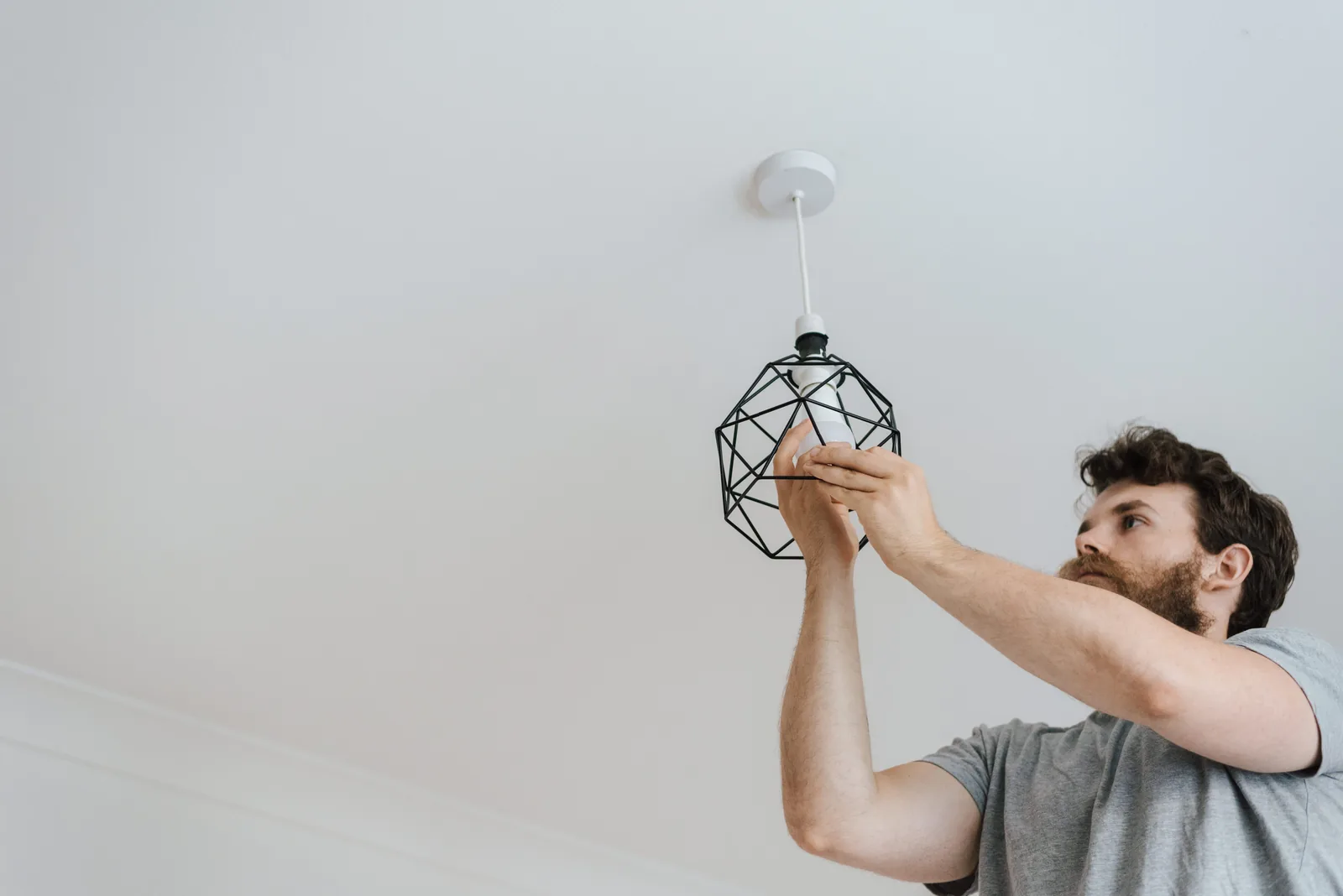 Fitting a lamp into a pendant fixture, for ev charger installation in Calgary
